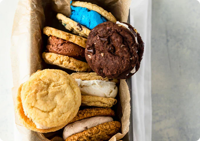 Cool Jacks handcrafted ice cream sandwiches stacked in a box with colorful cookies and creamy ice cream fillings.