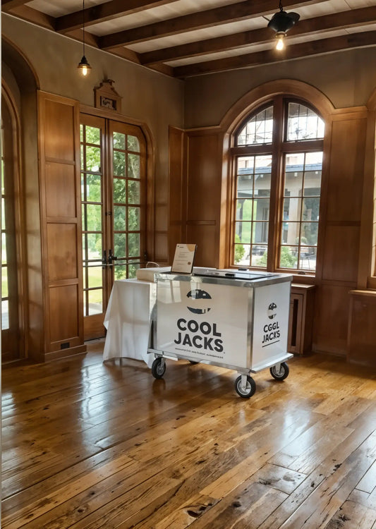 Cool Jacks ice cream cart set up indoors in a wooden room with tall windows, sunlight streaming in, creating a warm and inviting event vibe.