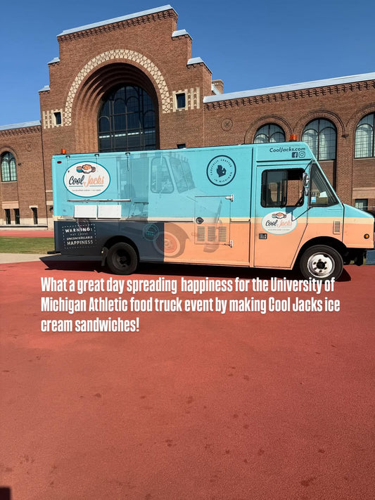 A teal and peach Cool Jacks ice cream sandwich food truck parked outside a large, historic brick building.