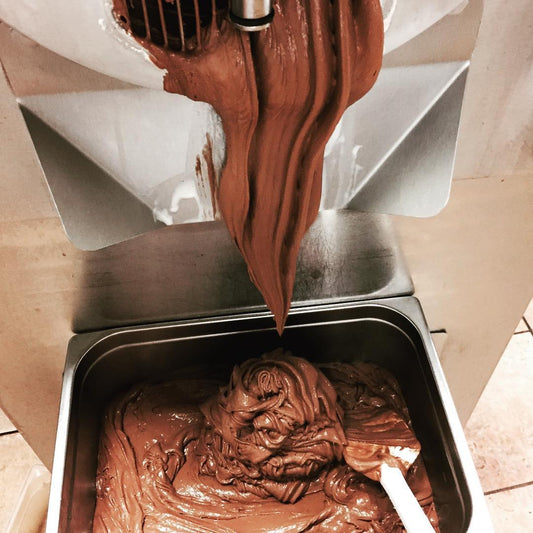 Close-up of creamy Cool Jacks chocolate ice cream slowly churning in a stainless steel container.