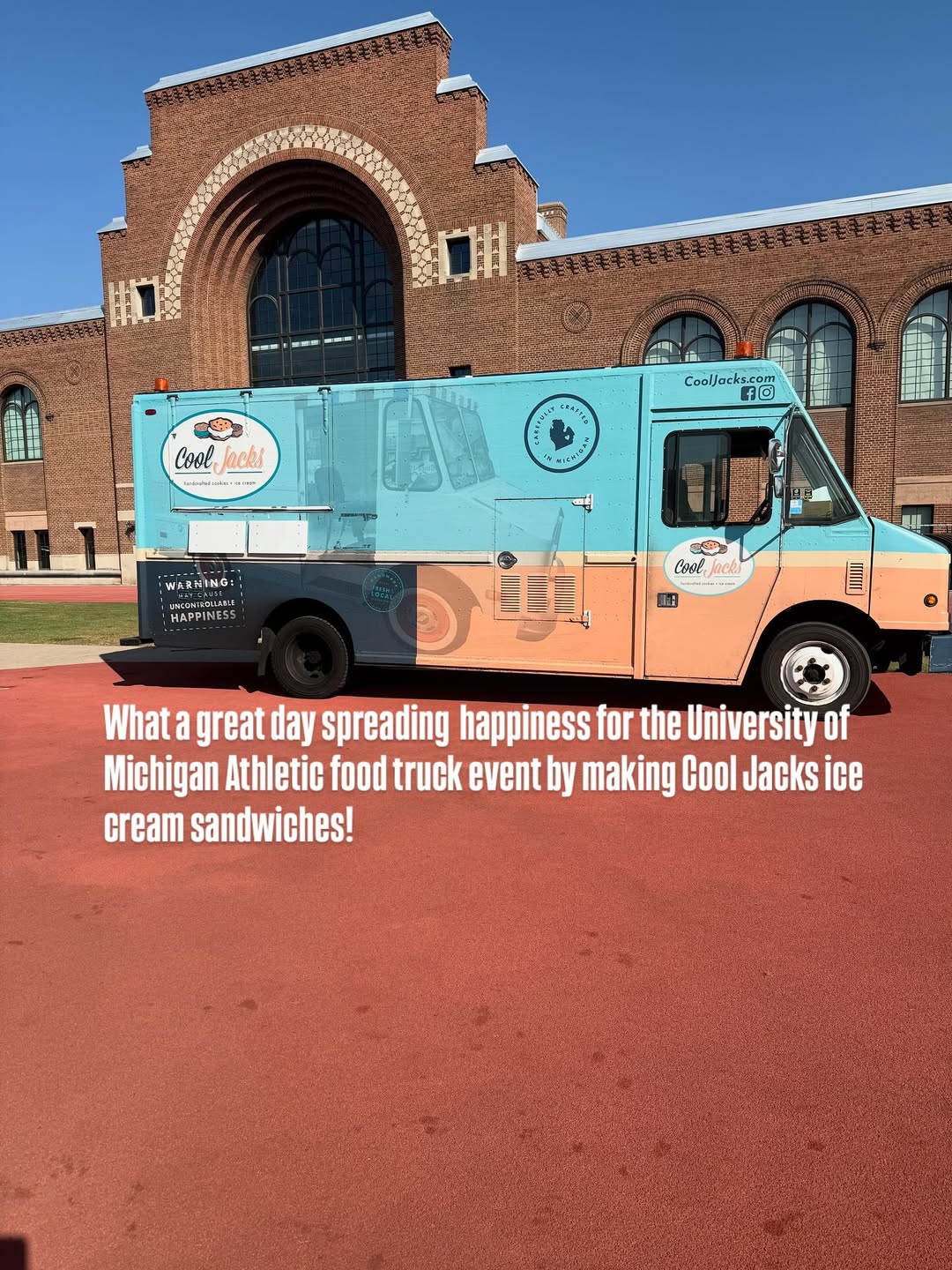 A teal and peach Cool Jacks ice cream sandwich food truck parked outside a large, historic brick building.
